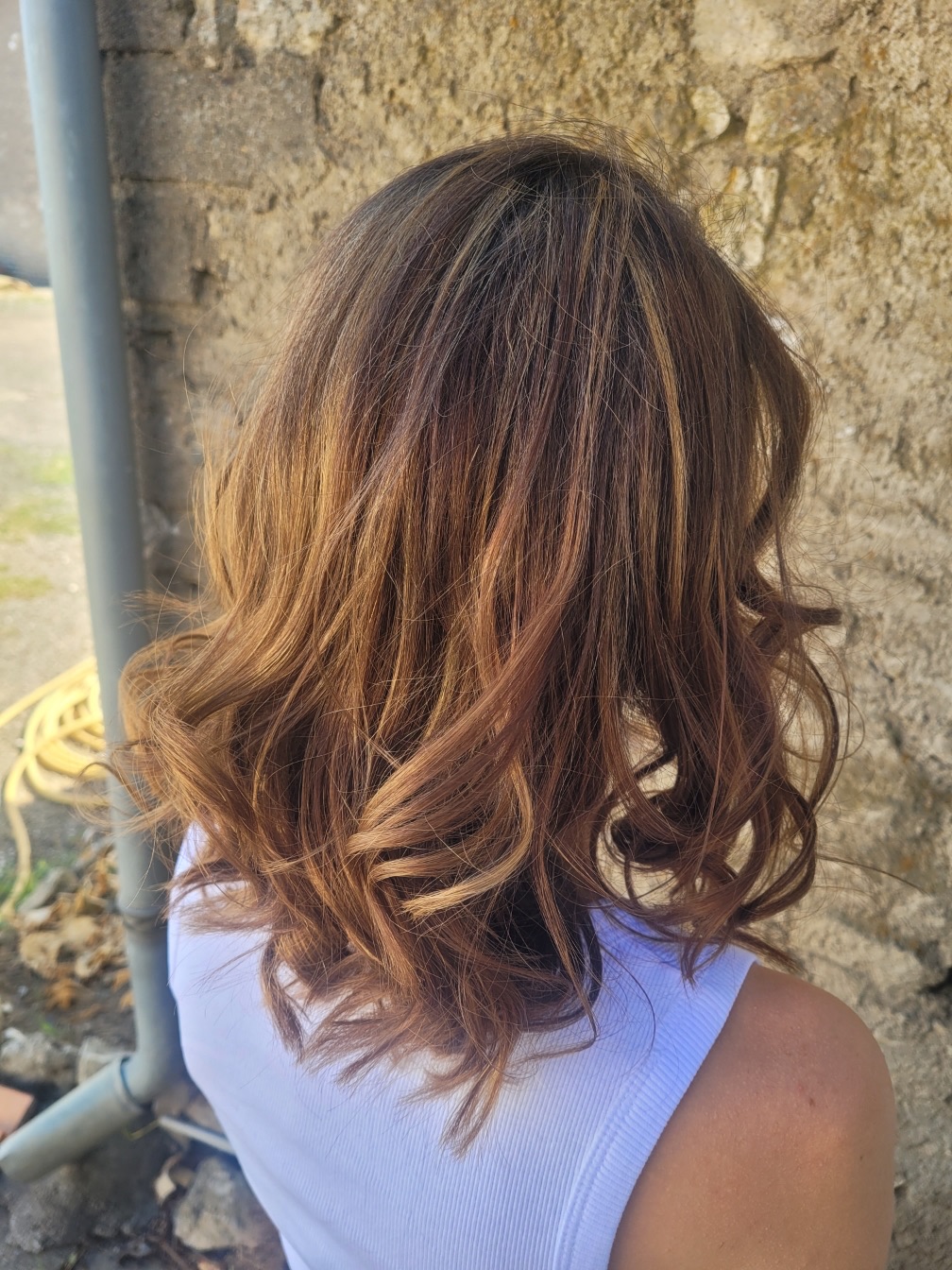 Balayage caramel sur carré long bouclé